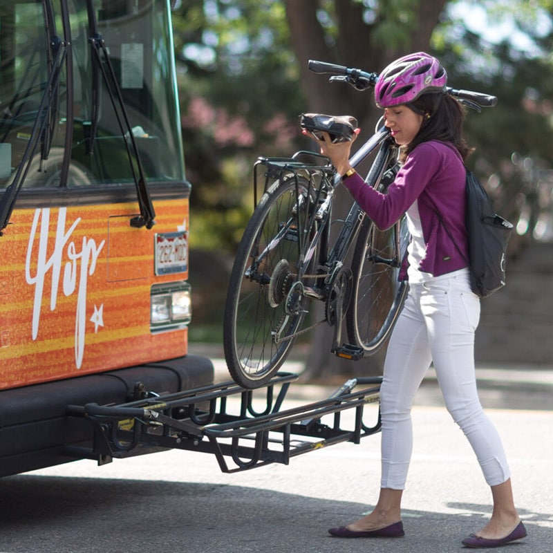 Cyclist using bus bicycle rack
